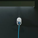 An einer Wand montierter go-e charger gemini 11kw mit angestecktem Typ 2 Ladekabel während eines Ladevorganges.